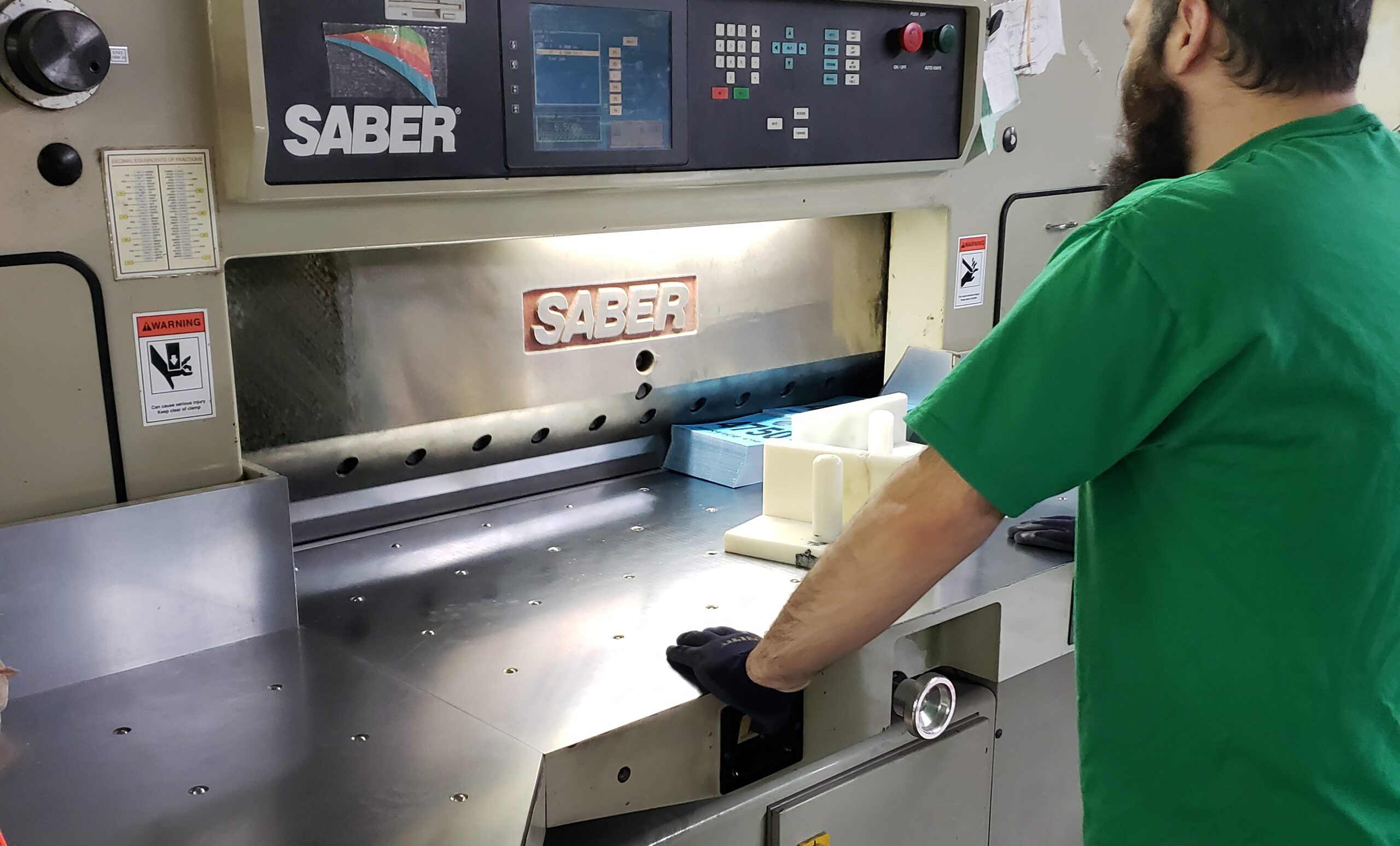 man operating paper cutter